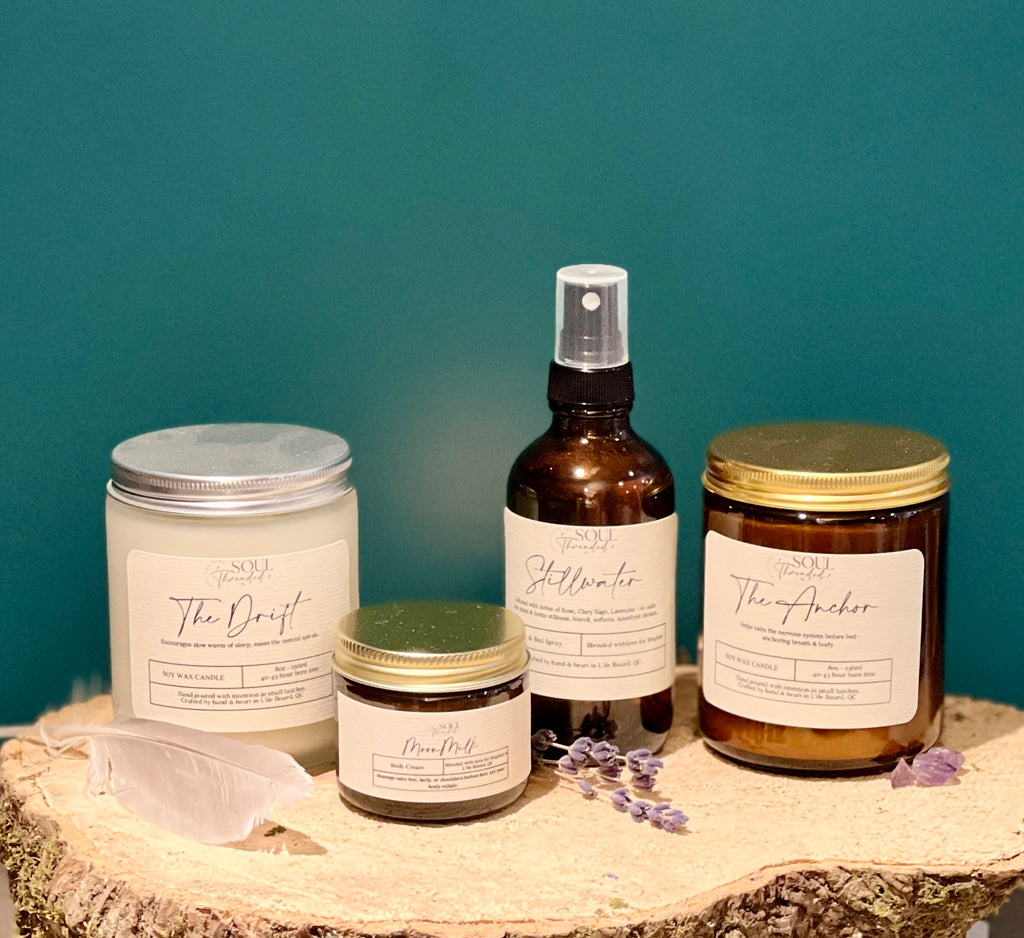 Collection of skincare products including jars and a spray bottle on a wooden surface with a teal background.
